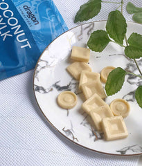 Plate of coconut milk cubes with a package of Dragon Superfoods coconut milk in the background.