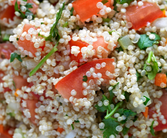A fresh, colorful Mediterranean quinoa salad bowl with cucumbers, tomatoes, and parsley, showcasing Soul Organic White Quinoa from Phytamins