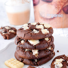 Stack of chocolate cookies with white chunks on a plate with a blurred background